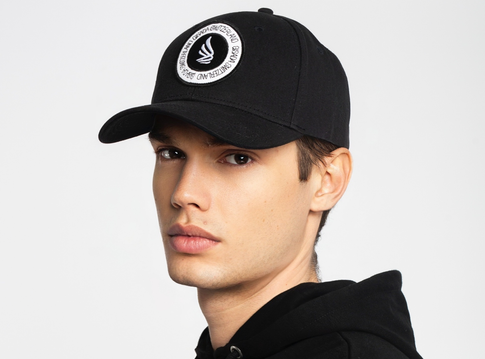Man wearing black baseball cap with Gisada Switzerland logo